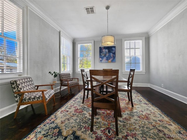 dining room with dark wood-type flooring, a wealth of natural light, and ornamental molding