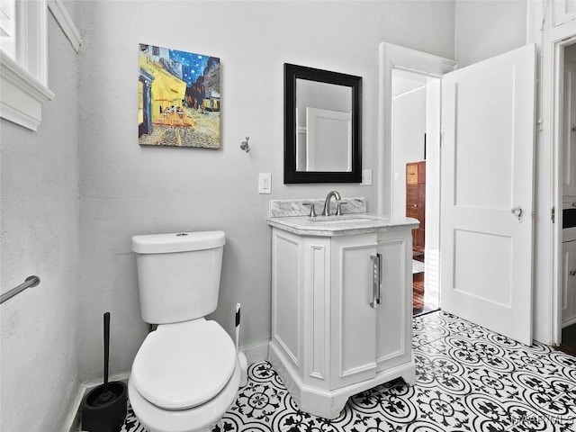 bathroom with tile patterned flooring, vanity, and toilet