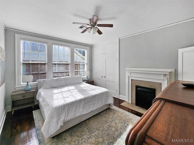 bedroom with ceiling fan, dark hardwood / wood-style floors, and a closet