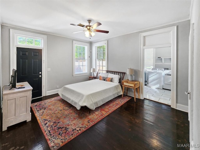 bedroom with washer and dryer, multiple windows, ceiling fan, and dark wood-type flooring