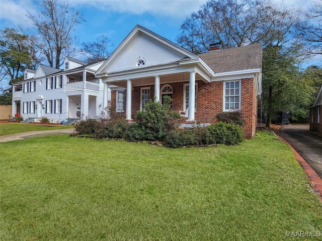 greek revival house with a balcony, central AC unit, and a front lawn