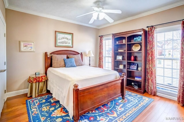 bedroom with ceiling fan, light wood-type flooring, and crown molding