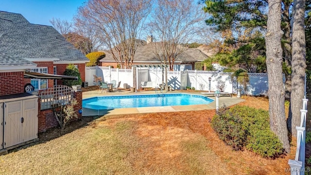 view of swimming pool featuring a shed, a patio area, and a lawn