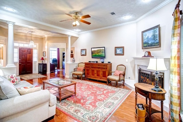 living room featuring wood-type flooring, a textured ceiling, and ornamental molding