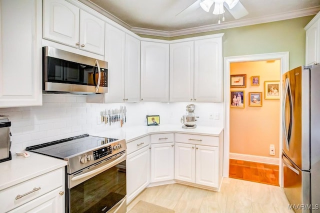 kitchen with backsplash, white cabinets, crown molding, ceiling fan, and appliances with stainless steel finishes