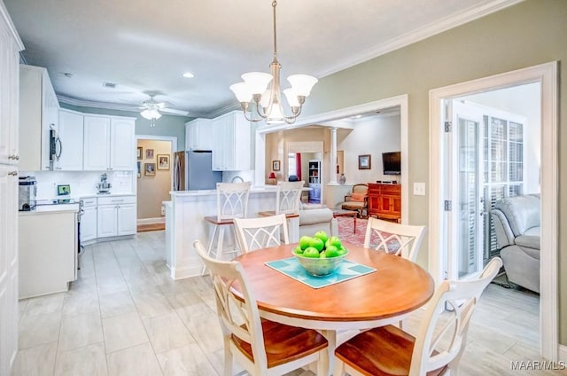 dining space featuring ceiling fan with notable chandelier and ornamental molding