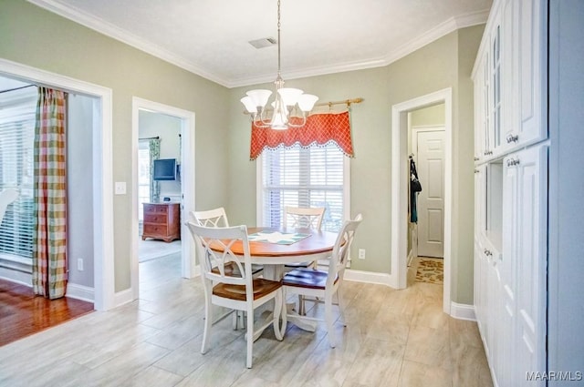 dining area featuring light hardwood / wood-style flooring, crown molding, and an inviting chandelier