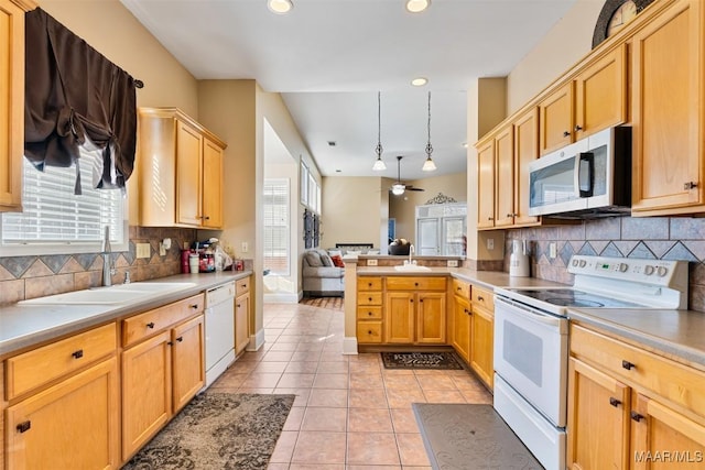 kitchen featuring sink, hanging light fixtures, light tile patterned floors, kitchen peninsula, and white appliances