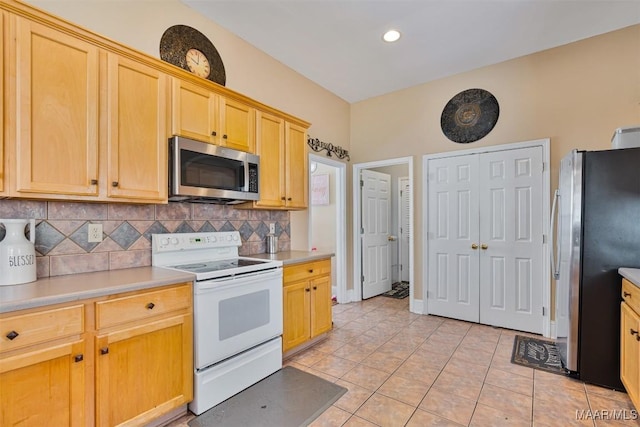 kitchen with tasteful backsplash, stainless steel appliances, light brown cabinetry, and light tile patterned floors