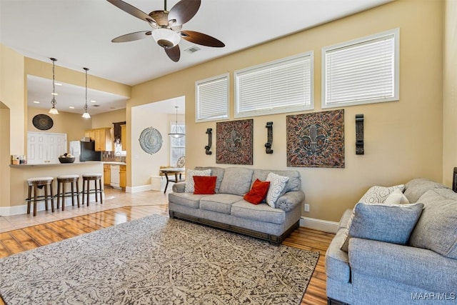 living room featuring ceiling fan and light wood-type flooring