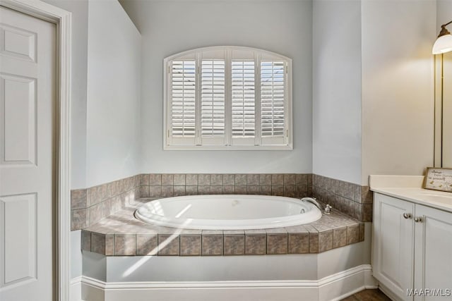 bathroom featuring vanity and tiled tub