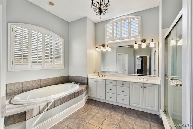 bathroom featuring vanity, tiled bath, and tile patterned flooring