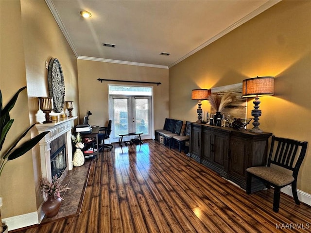 sitting room featuring a tiled fireplace, hardwood / wood-style flooring, crown molding, and french doors