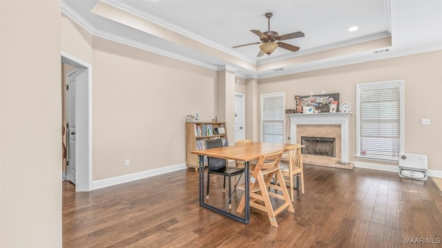 dining room featuring a tray ceiling, ceiling fan, crown molding, and dark hardwood / wood-style floors