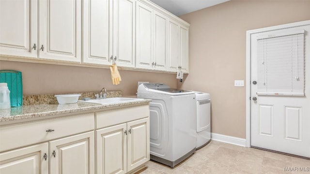 laundry area featuring cabinets, washing machine and clothes dryer, and sink