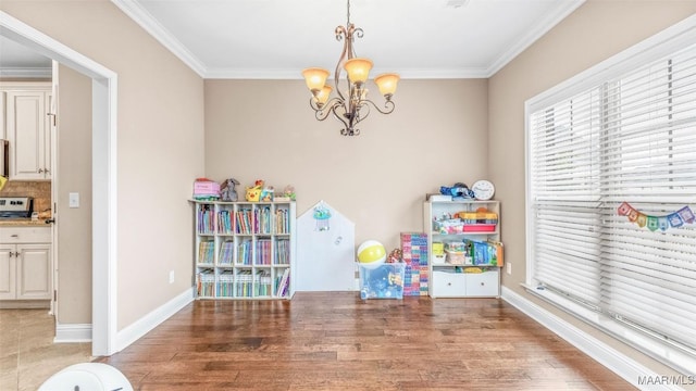 rec room featuring a chandelier, wood-type flooring, and ornamental molding