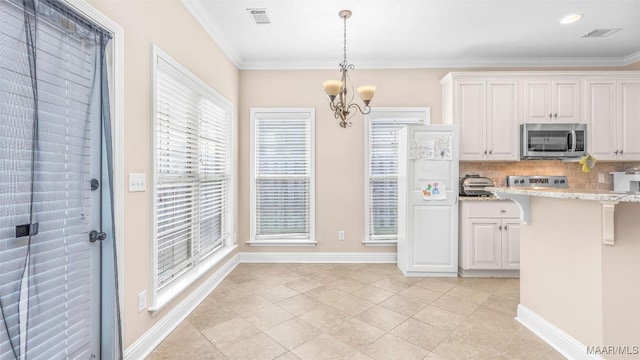 kitchen featuring an inviting chandelier, white cabinets, crown molding, hanging light fixtures, and light tile patterned floors