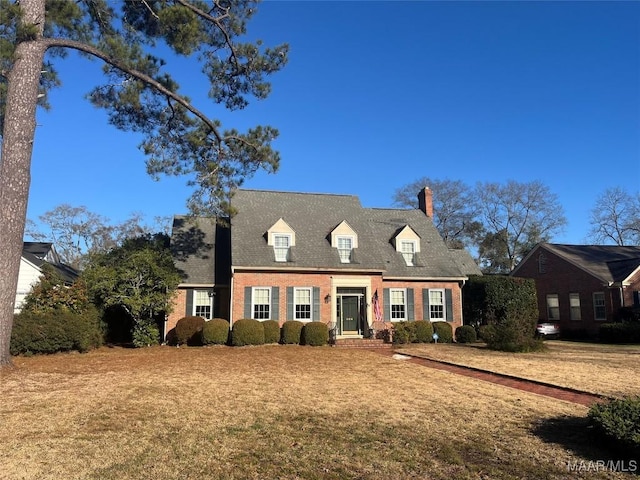 cape cod-style house with a front lawn