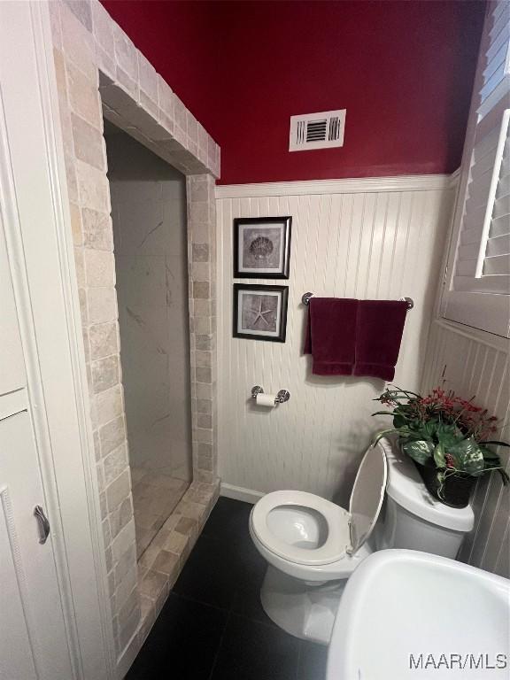 bathroom featuring a tile shower, tile patterned flooring, and sink