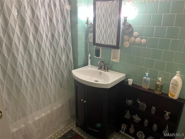 bathroom featuring vanity, tile walls, shower / bath combo with shower curtain, and backsplash