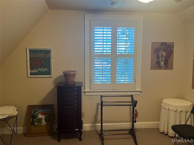 living area featuring carpet and vaulted ceiling