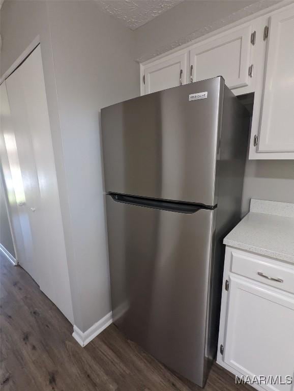 kitchen featuring white cabinets, stainless steel fridge, a textured ceiling, and dark hardwood / wood-style floors