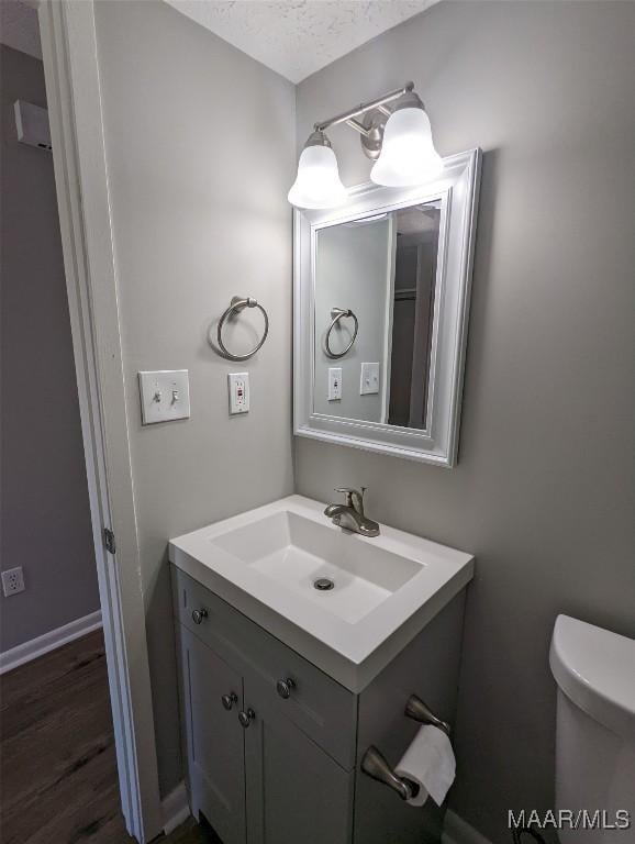 bathroom featuring vanity, a textured ceiling, and toilet