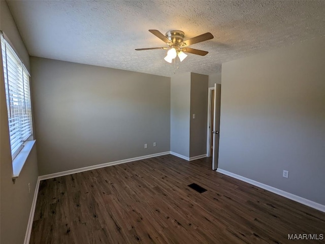 spare room featuring a textured ceiling, ceiling fan, and dark hardwood / wood-style floors