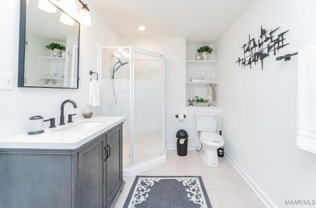 bathroom featuring tile patterned floors, vanity, a shower with shower door, and toilet