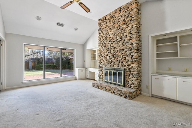 unfurnished living room with ceiling fan, a stone fireplace, built in features, high vaulted ceiling, and light carpet