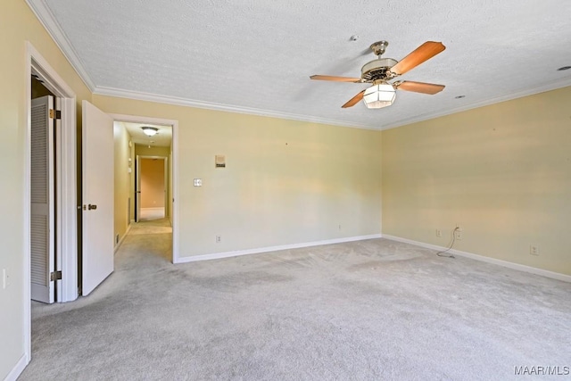 carpeted spare room featuring crown molding, ceiling fan, and a textured ceiling