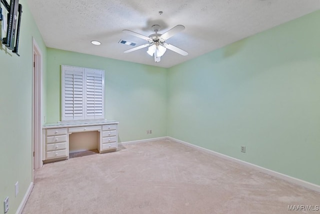 unfurnished bedroom featuring ceiling fan, a textured ceiling, and light carpet