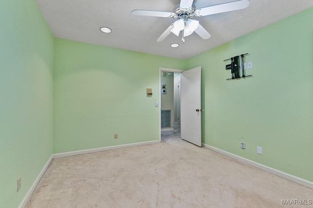 carpeted spare room with ceiling fan