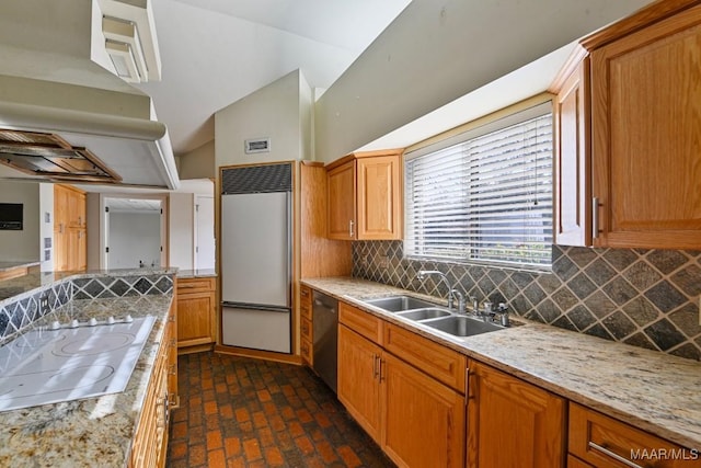 kitchen featuring backsplash, built in fridge, sink, stainless steel dishwasher, and electric stovetop