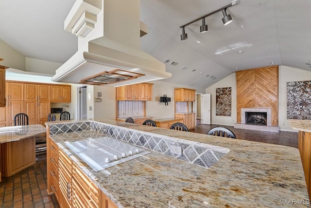 kitchen with a fireplace, island range hood, light stone counters, and white electric stovetop