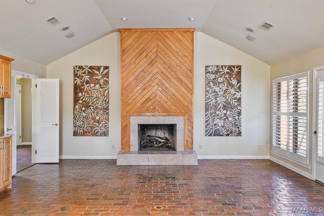 unfurnished living room with wooden walls, a fireplace, and lofted ceiling