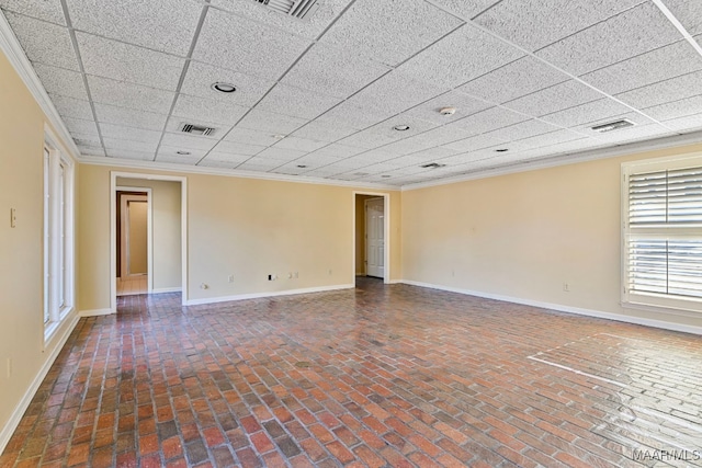 empty room featuring a paneled ceiling and ornamental molding