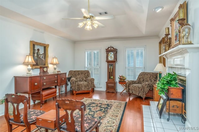 sitting room with crown molding, hardwood / wood-style floors, and ceiling fan