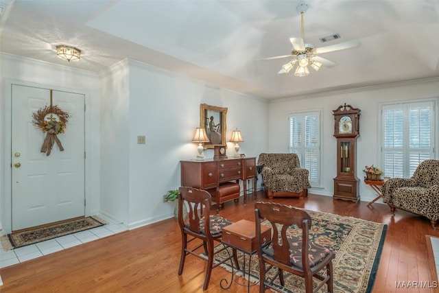 interior space with hardwood / wood-style floors, ceiling fan, and ornamental molding