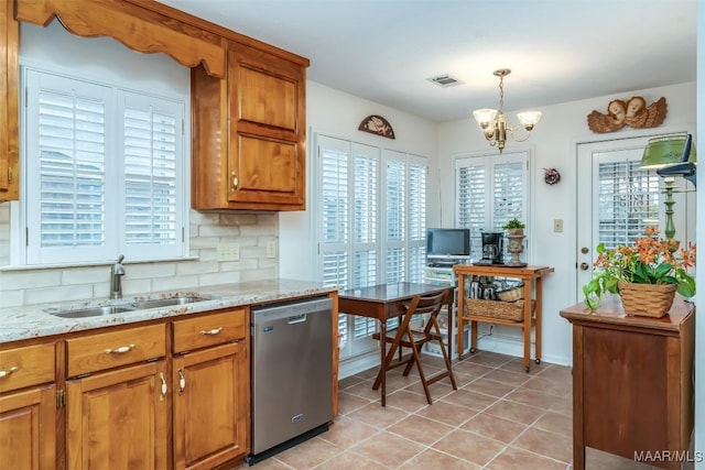 kitchen featuring pendant lighting, sink, stainless steel dishwasher, decorative backsplash, and a chandelier