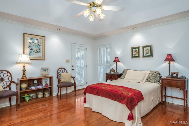 bedroom featuring hardwood / wood-style flooring, ceiling fan, and ornamental molding