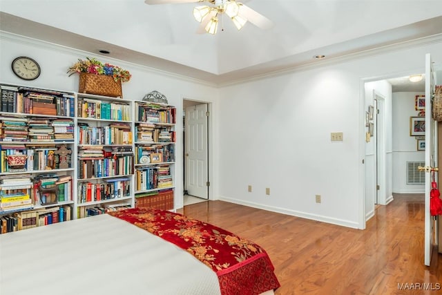 bedroom featuring wood-type flooring, ceiling fan, and crown molding