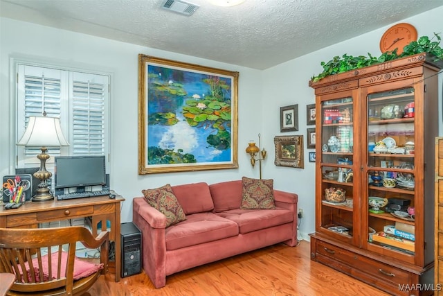 living area featuring light hardwood / wood-style floors and a textured ceiling