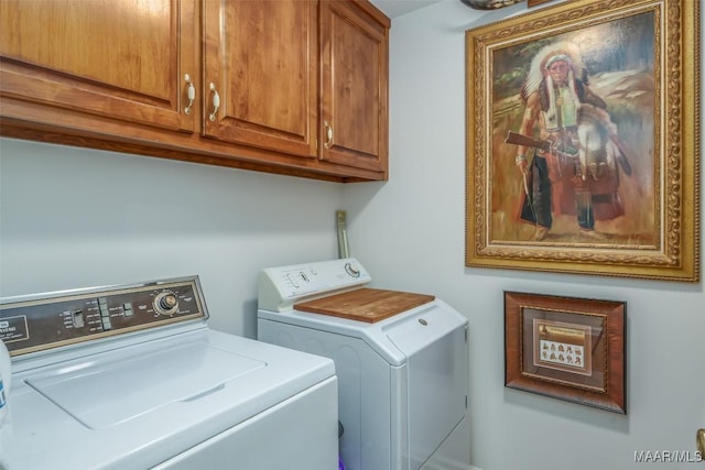 clothes washing area featuring cabinets and washing machine and dryer