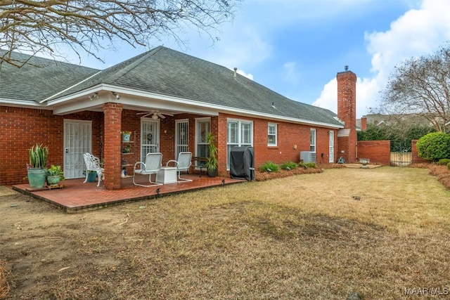 rear view of property featuring a yard, ceiling fan, and a patio area