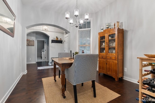 dining area with a notable chandelier and dark hardwood / wood-style flooring