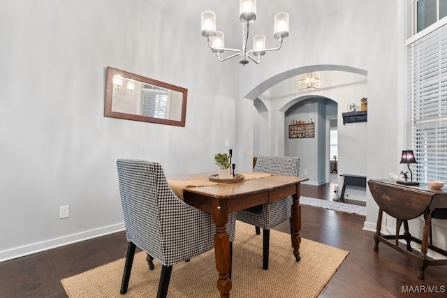 dining space featuring dark wood-type flooring and a notable chandelier