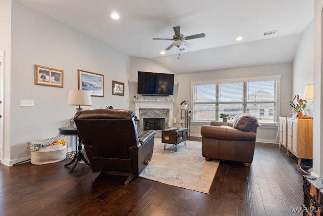 living room with hardwood / wood-style flooring, ceiling fan, lofted ceiling, and a high end fireplace