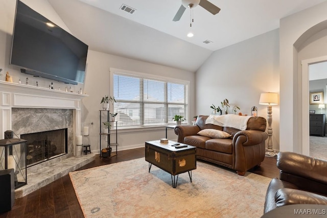 living room with ceiling fan, wood-type flooring, a fireplace, and vaulted ceiling