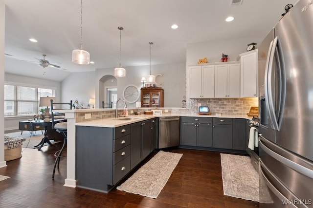 kitchen featuring white cabinets, a kitchen breakfast bar, decorative light fixtures, kitchen peninsula, and stainless steel appliances